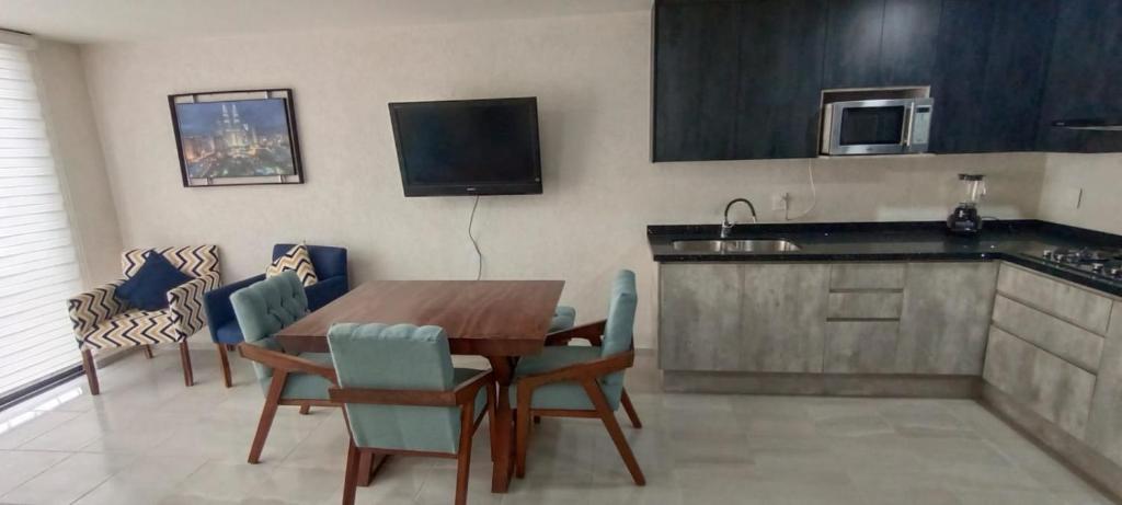uma cozinha com uma mesa e cadeiras e um micro-ondas em Beautiful and modern apartment em Tonalá