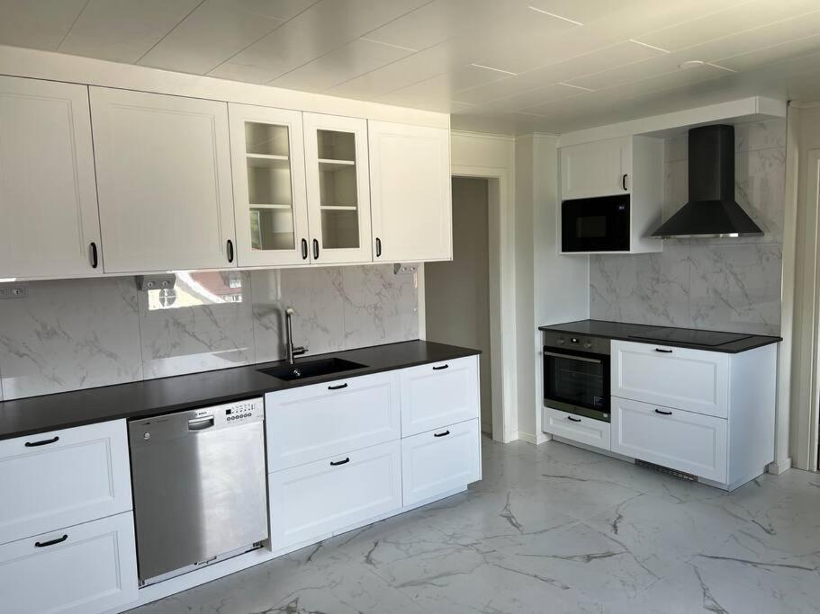 a kitchen with white cabinets and black counter tops at Härligt stort boende i perfekt läge in Borås