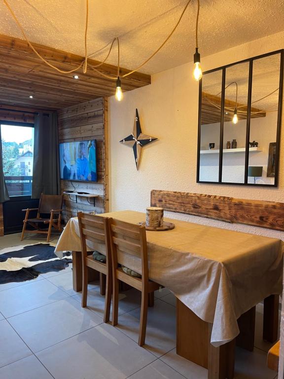Le repère de Bianca, le premier de cordée في مونجينيفر: غرفة طعام مع طاولة ونجمة على الحائط