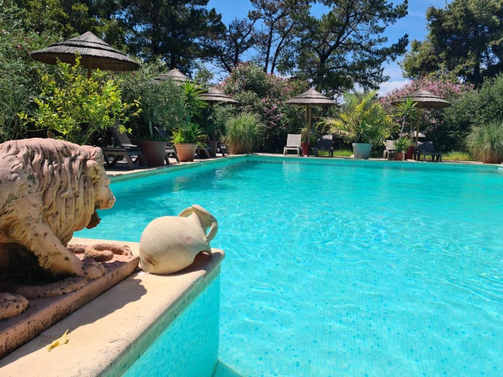 a swimming pool with a statue next to a swimming pool at Relais de Bravone in Linguizzetta