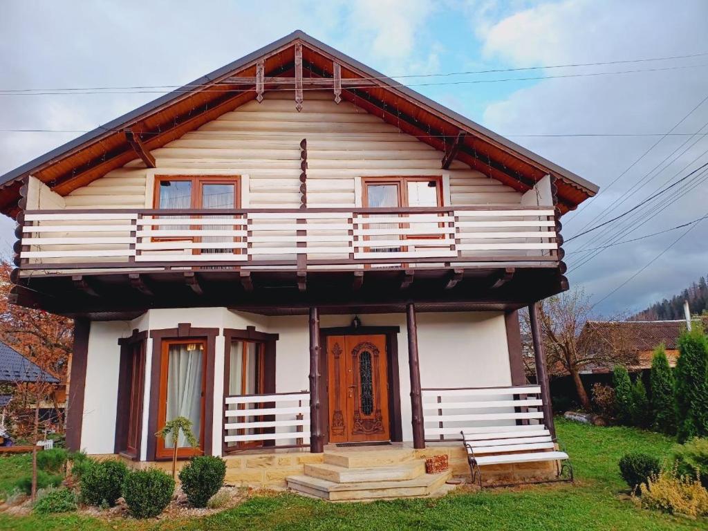 ein kleines weißes Haus mit einer roten Tür in der Unterkunft Villa Zgarda1 in Mykulytschyn