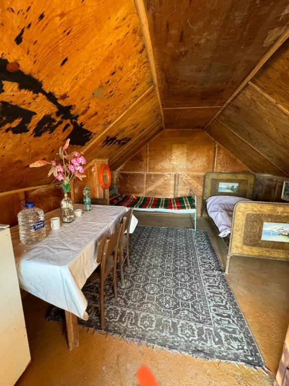 a dining room with a table and a bed in a room at Къща до Казанлък 2 Стаи 3 Легла, Няма Ток и Вода, на Самомениджмънт in Kazanlŭk