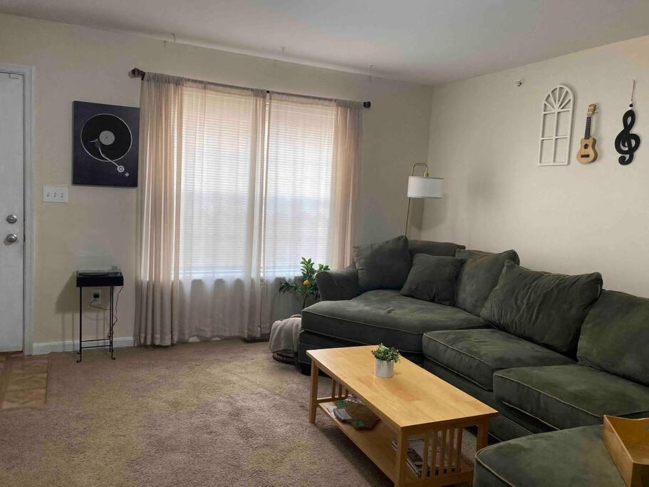 a living room with a green couch and a table at Midtown Harrisburg Townhouse in Harrisburg