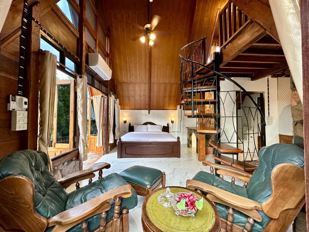 a living room with a staircase and a bedroom at Ban Kaew Mo Ra Glamping & Restaurant in Pang Mapha