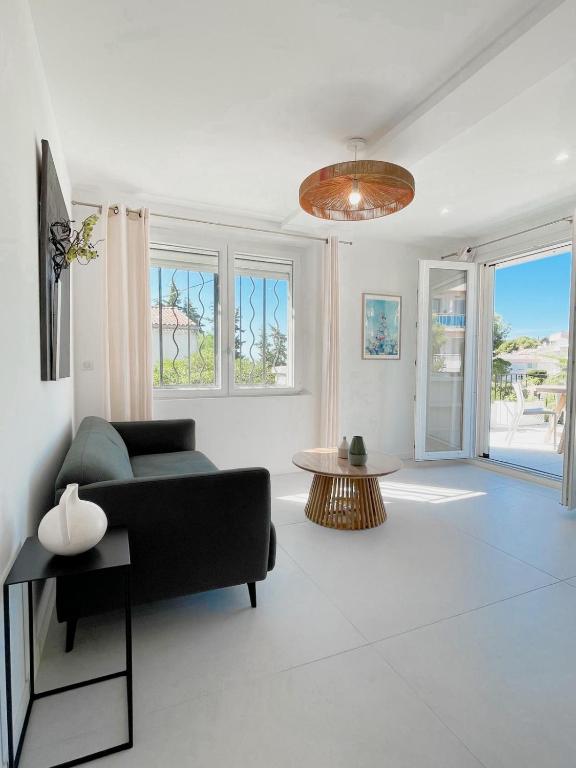 un salon avec un canapé et une table dans l'établissement Petit Vallon - Wifi - Parking - 2 Chbres - Clim, à Cassis