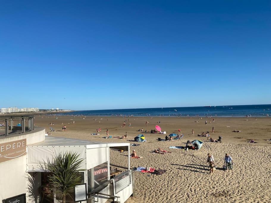 a group of people on a beach near the ocean at Appartement en plein cœur du centre ville in Les Sables-d'Olonne