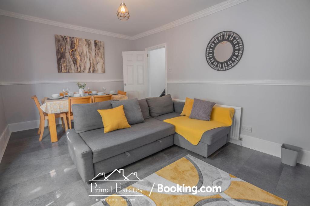 a living room with a gray couch and yellow pillows at Two Bed House At Primal Estates Short Lets in Brighton in Brighton & Hove