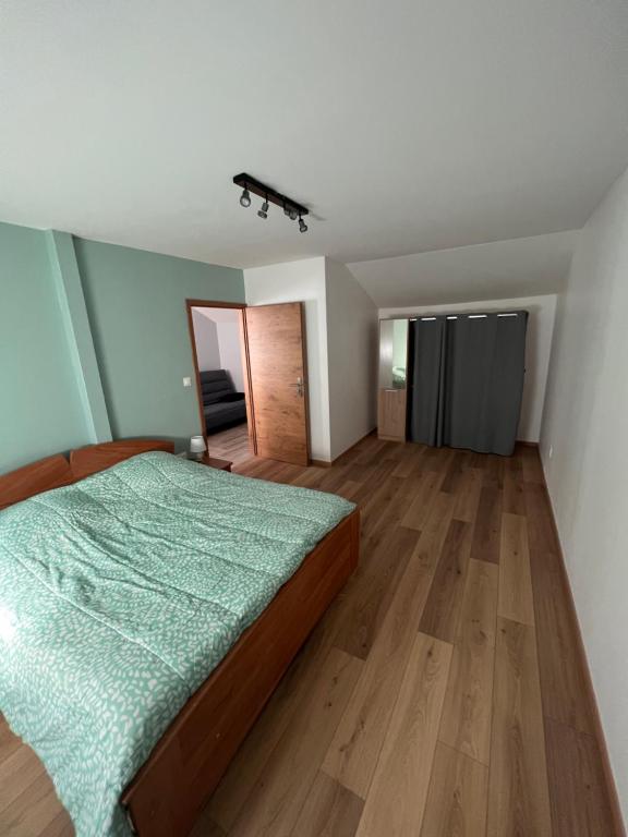 1 dormitorio con 1 cama y suelo de madera en Gîte chez Audrey et Pascal, en Westhouse