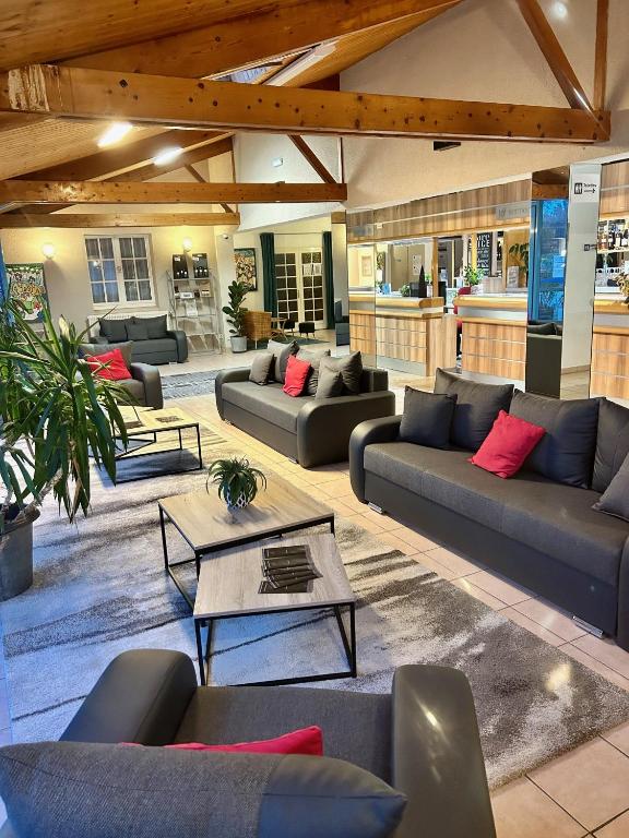 un grand salon avec des canapés et des tables dans l'établissement Hôtel Particulier LE MAS DES MARAIS, à Machecoul