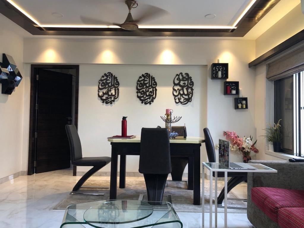 a living room with a table and chairs at The Luxurious Haven-Lokhandwala in Mumbai