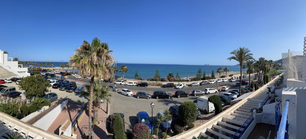 a parking lot with palm trees and the ocean at mirazul mojacar in Mojácar