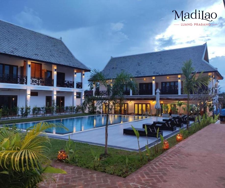 a hotel with a swimming pool in front of a building at Madilao Hotel in Luang Prabang