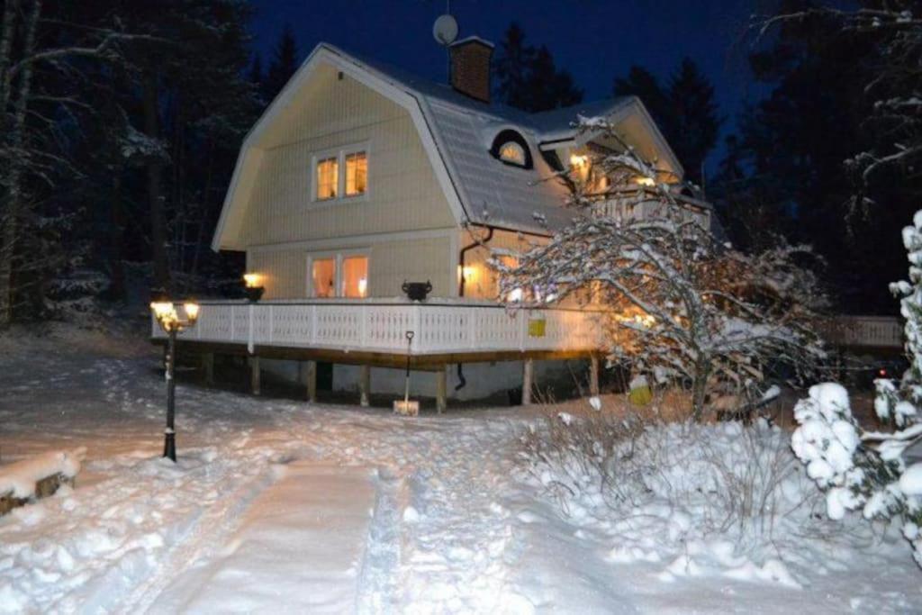 a large house in the snow at night at Havsnära Motorbåt 12 Cyklar 18+Beds VedBastu Hav! in Djurhamn