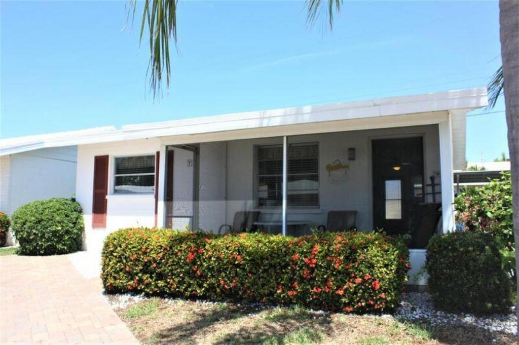 een gebouw met struiken en bloemen ervoor bij Villa 7 - Aloha Kai Vacation Villas in Siesta Key