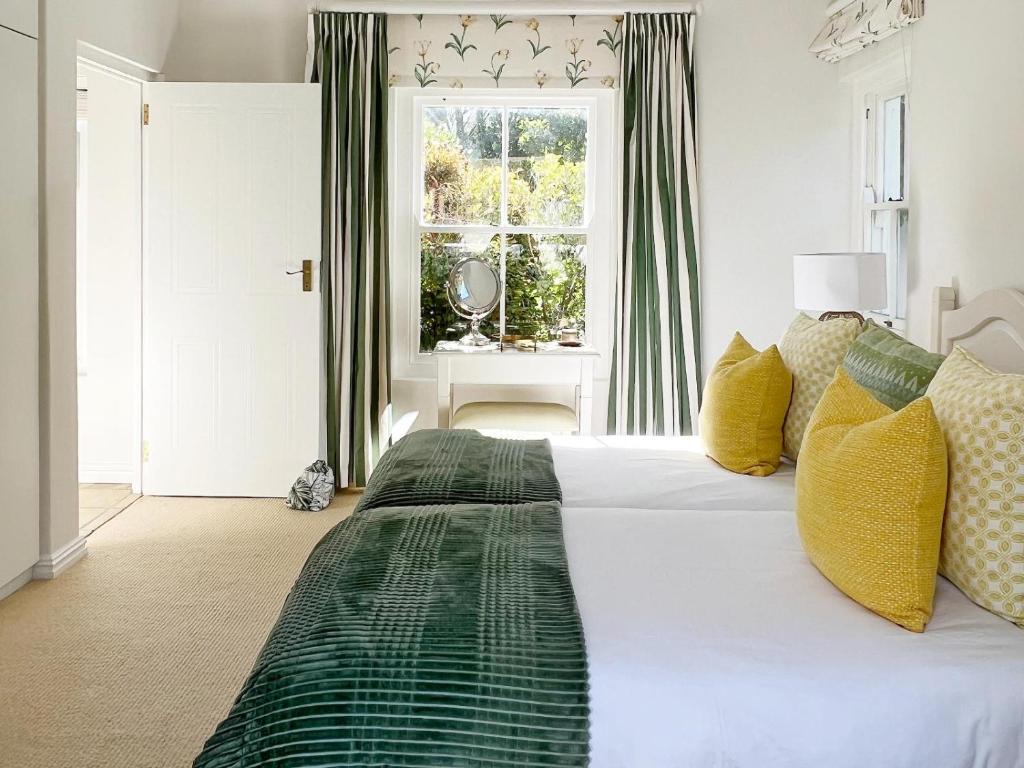 a bedroom with a green and white bed with a window at La Belle Vie in Franschhoek