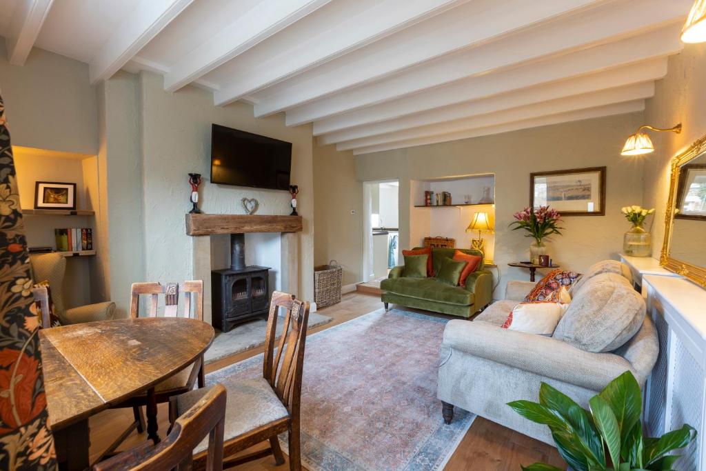 a living room with a couch and a fireplace at Bankside Cottage in Bedale