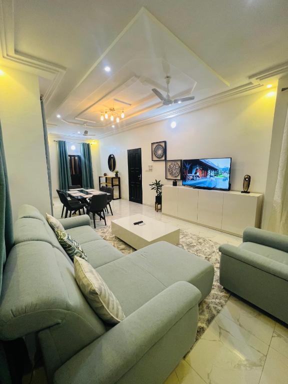 a living room with a couch and a tv at Magnifique appartement meublé 2 chambres in Lomé
