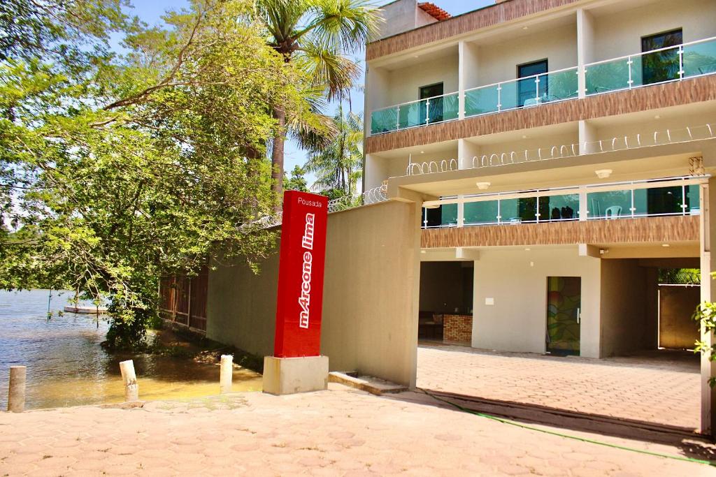 un edificio con una señal roja delante de él en Marcone Lima - Chalés, en Barreirinhas