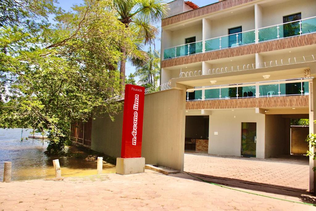 a building with a red sign in front of it at Marcone Lima - Chalés in Barreirinhas