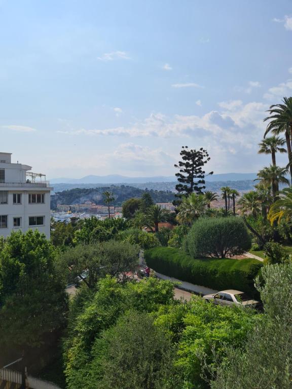 - une vue sur un parc arboré et un bâtiment dans l'établissement Appartement Les Oliviers, à Nice