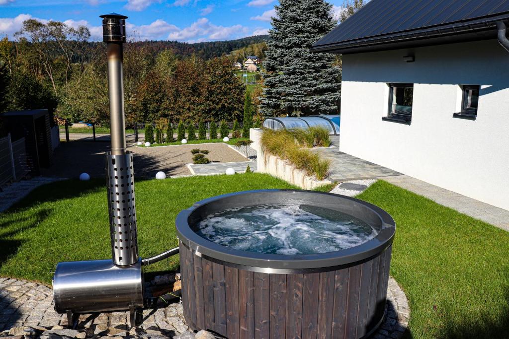 a hot tub in the backyard of a house at Domek Viking z prywatnym ogrzewanym basenem sauną oraz balią z jacuzzi in Gródek Nad Dunajcem