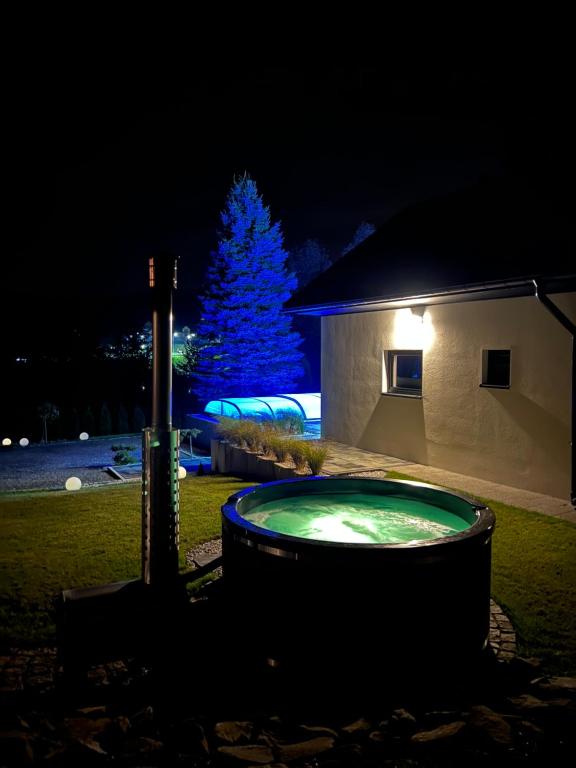 a christmas tree in front of a building with a hot tub at Domek Viking in Gródek Nad Dunajcem