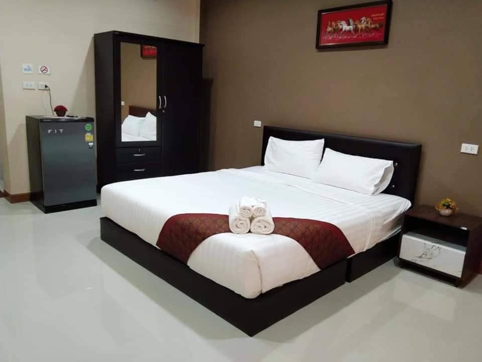 a bedroom with a large bed with two towels on it at Minton Resort มิลตั้น รีสอร์ท in Ban Kohong