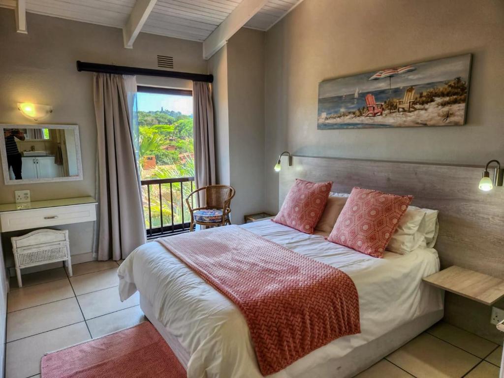 ein Schlafzimmer mit einem großen Bett und einem Fenster in der Unterkunft San Lameer 3125 by Top Destinations Rentals in Southbroom
