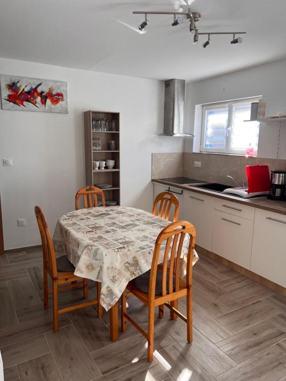 a kitchen with a table and chairs in a kitchen at Gîte chez Audrey et Pascal in Westhouse