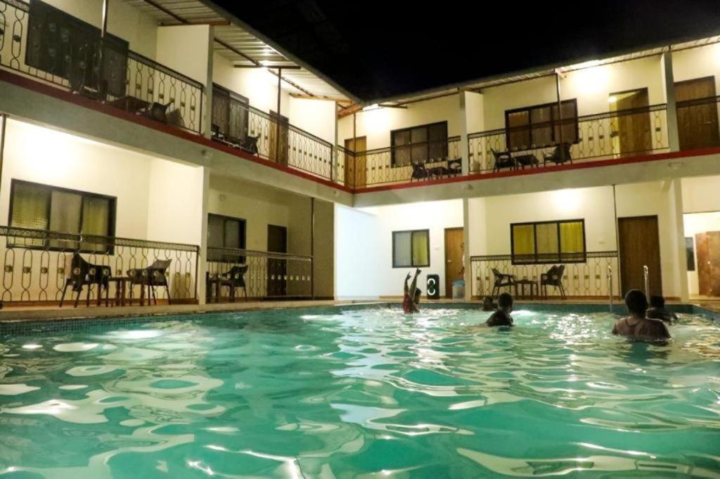 a group of people swimming in a swimming pool at Mokalbaug Beach Resort in Nagaon