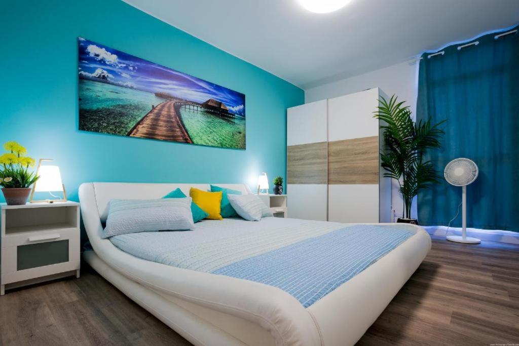 1 dormitorio con 1 cama grande y pared azul en GP127 apartman Tenerife, en San Miguel de Abona