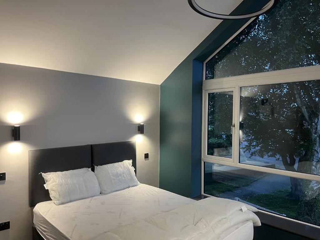 ein Schlafzimmer mit einem Bett und einem großen Fenster in der Unterkunft Welcome to your stay The Nest in Bolton