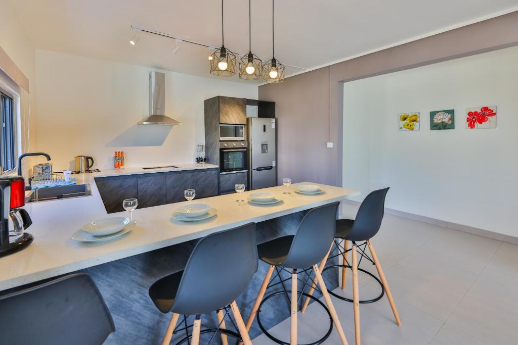 a kitchen with a table and chairs in a room at OceanBreeze Apartments Mont Choisy in Mont Choisy