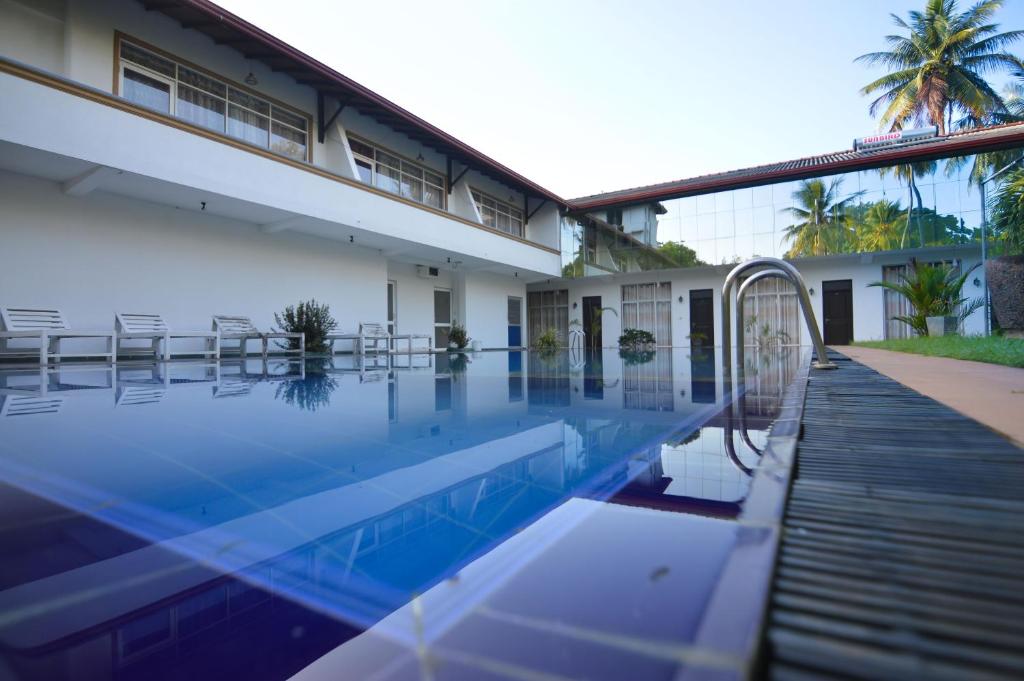 een zwembad voor een gebouw bij Siyanco Holiday Resort in Polonnaruwa