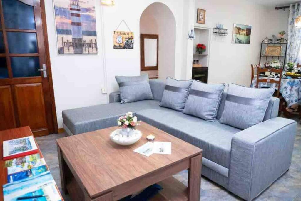 ein Wohnzimmer mit einem blauen Sofa und einem Tisch in der Unterkunft Vythee Residence in Chemin Grenier