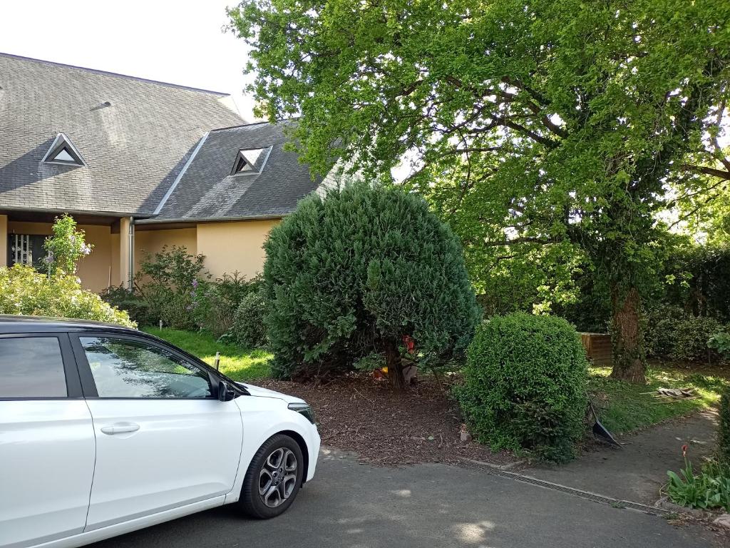a white car parked in front of a house at Logement indépendant avec parking privé et terrasse, au calme. in Coulaines