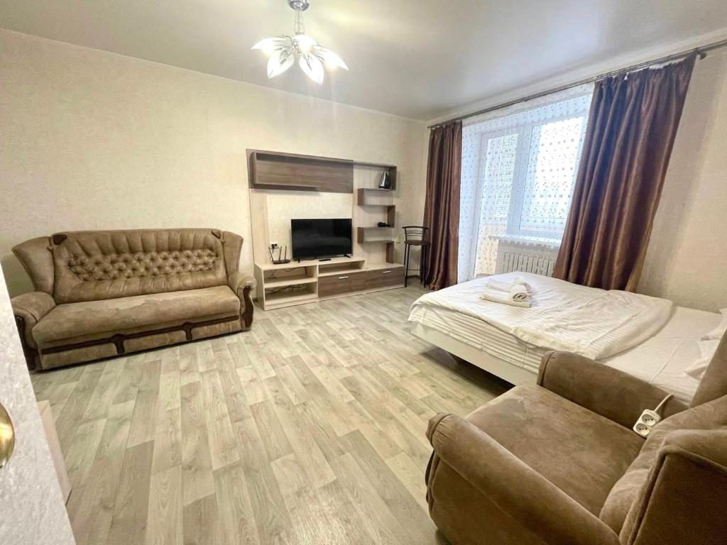 a living room with a bed and a couch at ApartPoltava Велика однокімнатна квартира в Новому будинку, ЦЕНТР МІСТА, Банківський ЧЕК in Poltava