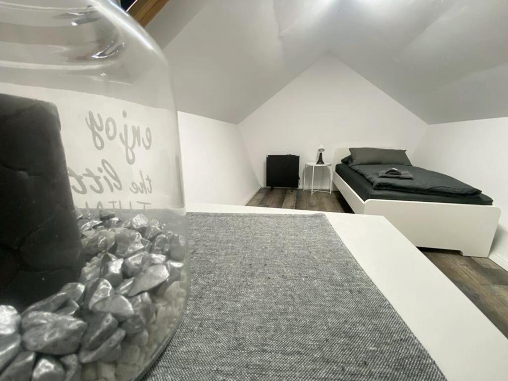 - une chambre avec un lit et un vase avec des rochers dans l'établissement Cozy Apartments in Zwickau, à Zwickau