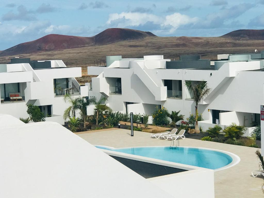 een wit gebouw met een zwembad ervoor bij CASA Pura Vida, Fuerteventura in La Oliva