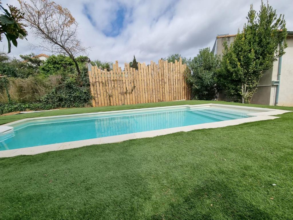 - une piscine dans une cour à côté d'une clôture dans l'établissement La Nouvelle Font Neuve BEZIERS - Famille - Enfants - Amis, à Béziers