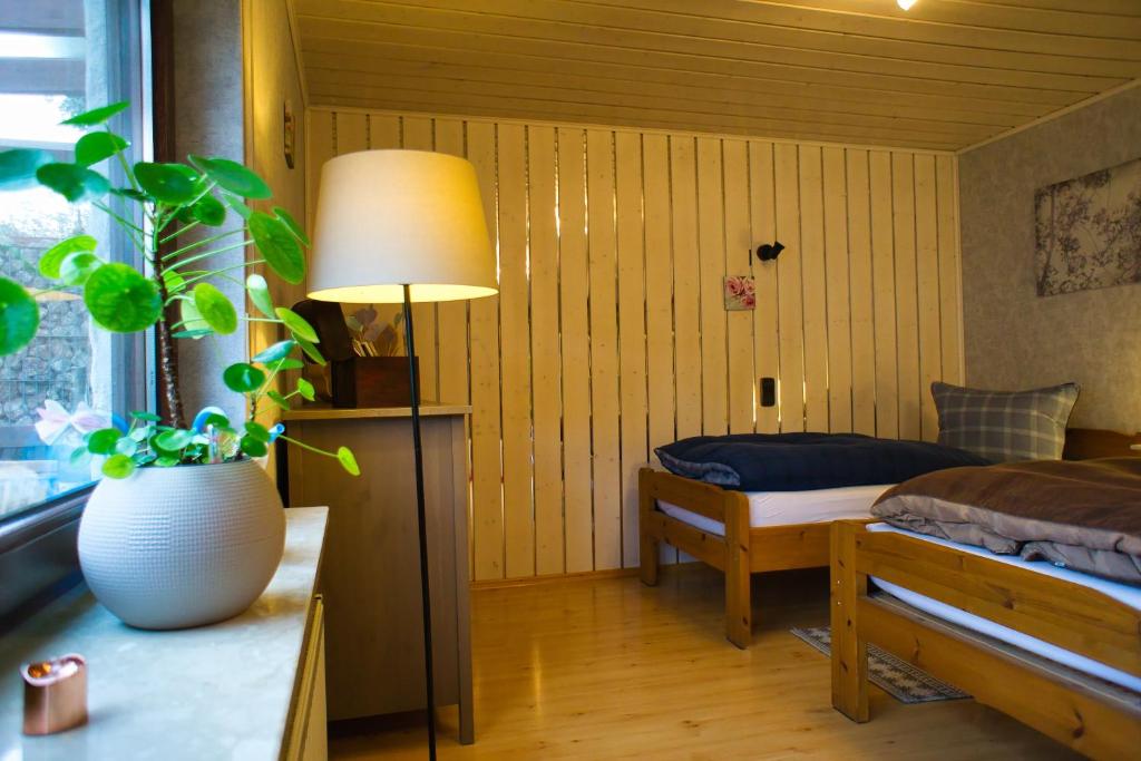 sypialnia z łóżkiem, lampką i rośliną w obiekcie Gemütliche Wohnung mit Neckarblick w mieście Eberbach