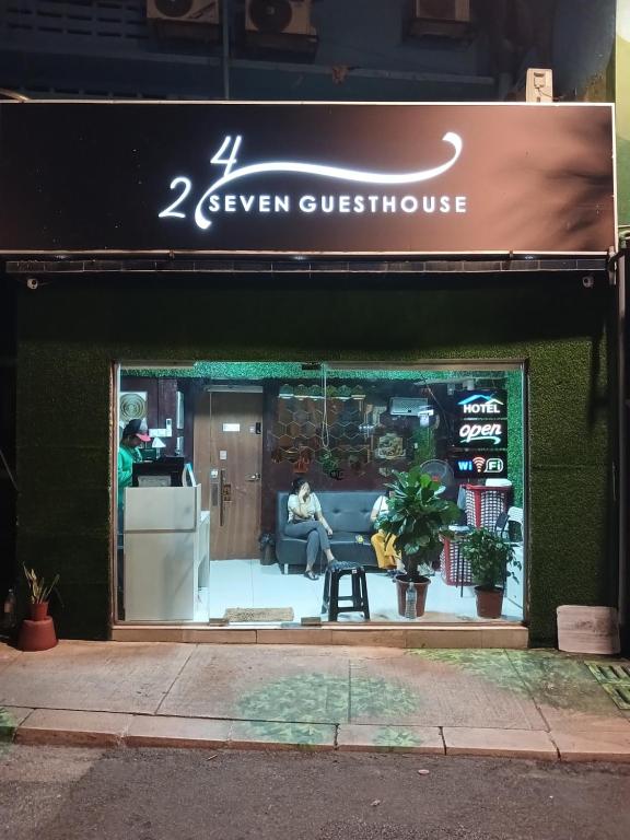 a woman sitting in a chair in a store window at 24Seven Guesthouse in Kuala Lumpur