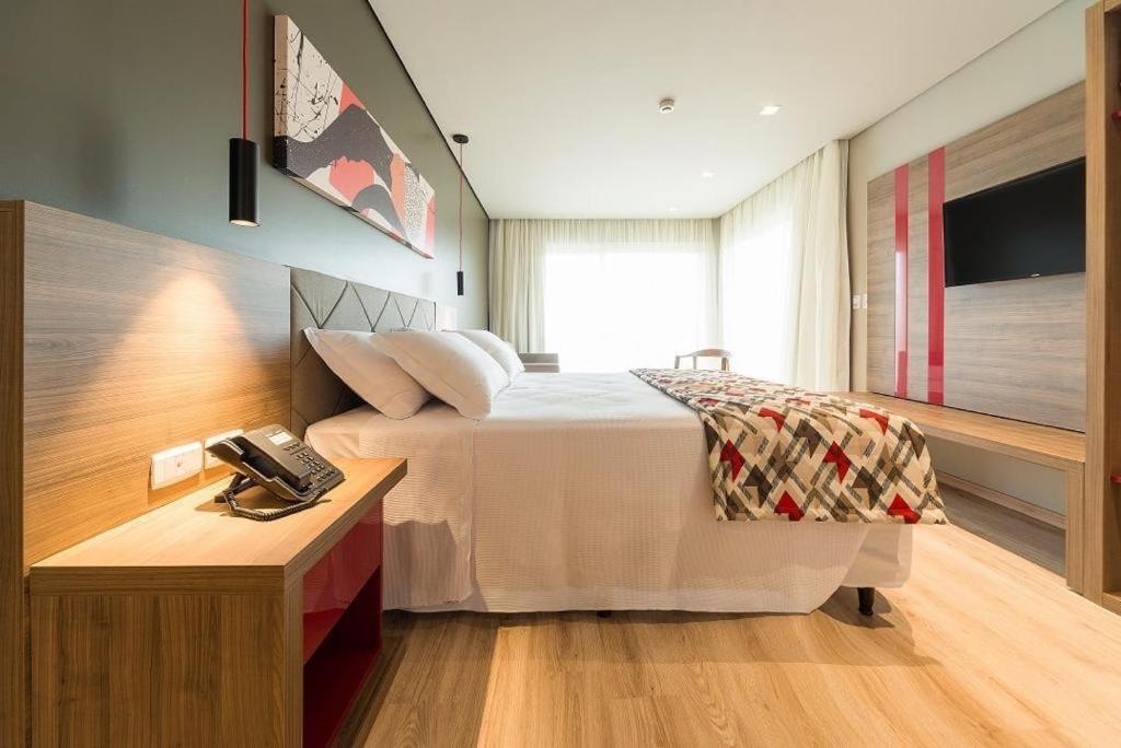 Habitación de hotel con cama y teléfono en Hotel Laghetto Stilo Borges apt 318 en Gramado
