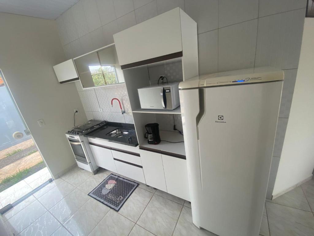 uma pequena cozinha com um frigorífico e um fogão em Casa confortável na terra das cataratas em Foz do Iguaçu