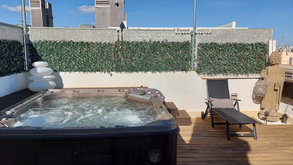 Ático de Lujo con Jacuzzi Climatizado en Terraza في إلتشي: حوض استحمام ساخن فوق الفناء