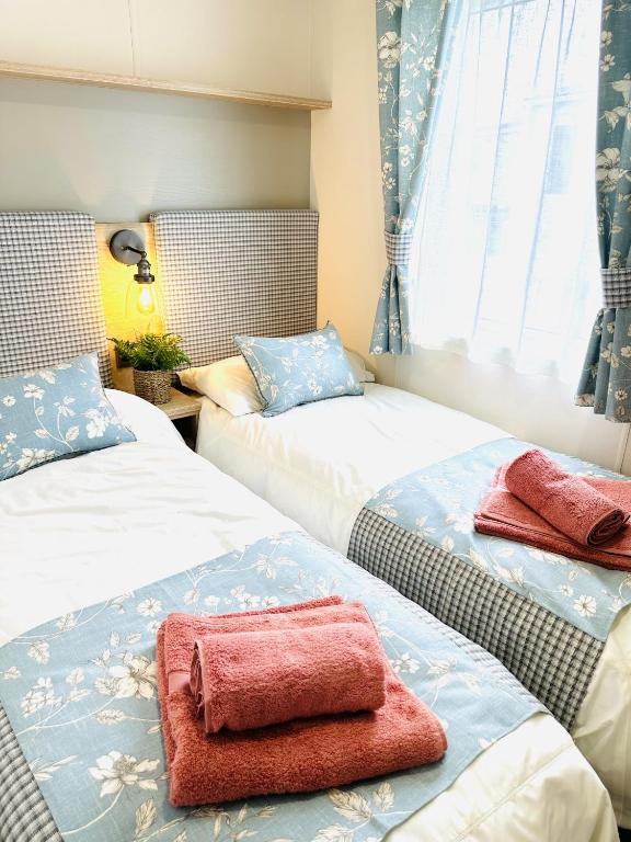 a bedroom with two beds with towels on them at Los Jameos in Scarborough