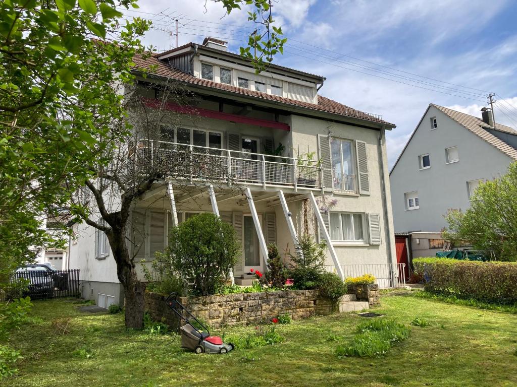 ein weißes Haus mit einer Veranda und einem Garten in der Unterkunft Haus am Bach in Schwäbisch Gmünd