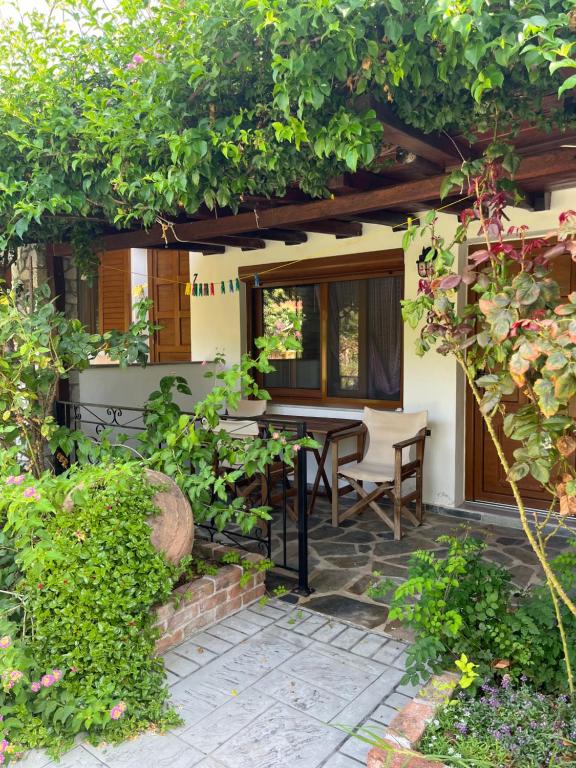 a patio with a table and chairs in a garden at Maniatis Garden in Achladies