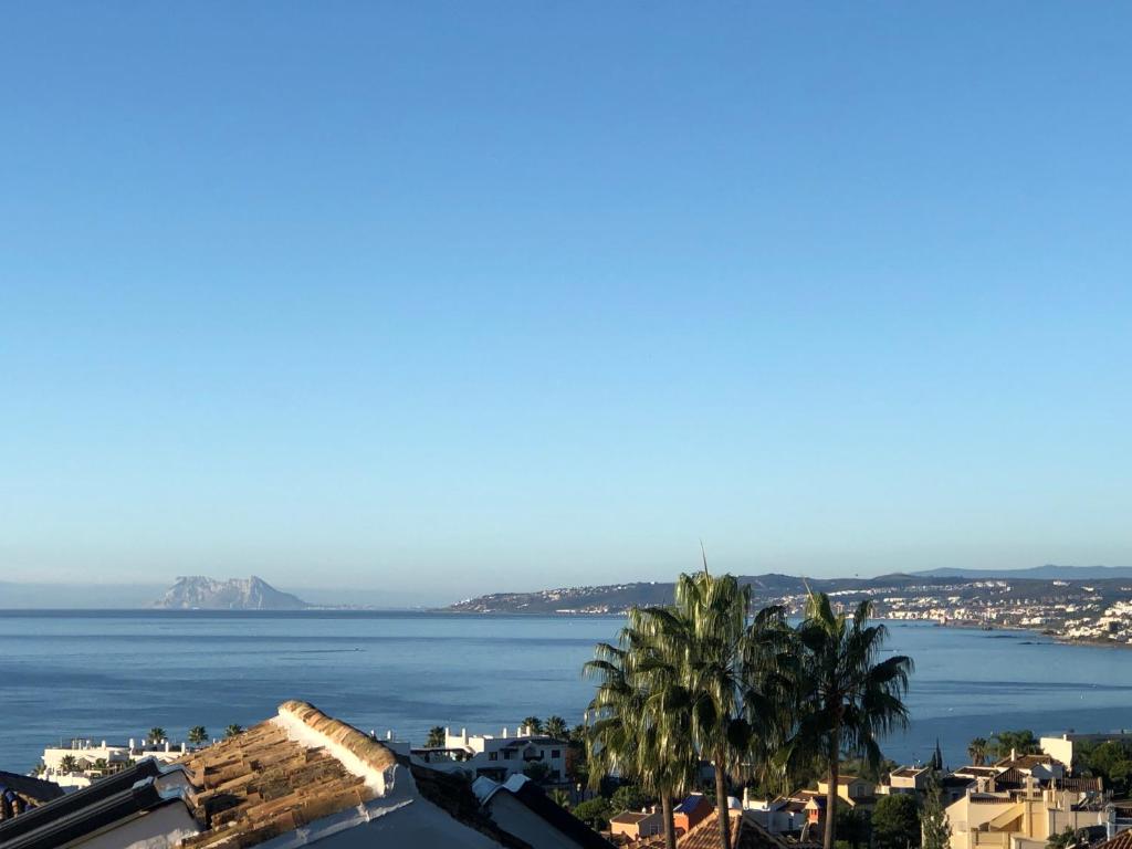 uma vista para um corpo de água com palmeiras em Mikaela Beach House Estepona Marbella Malaga em Estepona