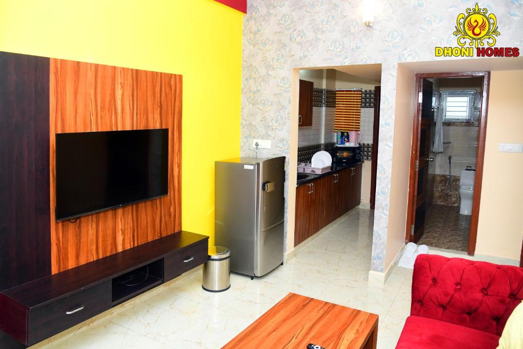 a living room with a flat screen tv on a wall at Dhoni Homes -Premium 1 BHK Service Apartment Manyata Tech Park in Bengaluru